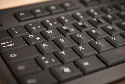 Computertastatur - © Wolfgang Ehrecke Schwarze Computertastatur in Nahaufnahme, Fokus auf Buchstabentasten in diagonaler Perspektive.