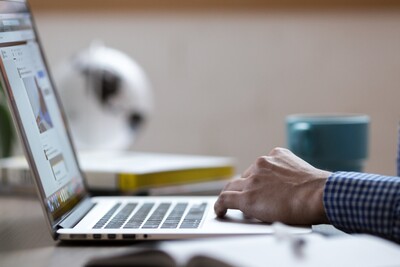 Agrarbüro - © StockSnap / pixabay.com Person in kariertem Hemd arbeitet an einem Laptop, daneben ein Notizbuch und eine Tasse auf einem Tisch.